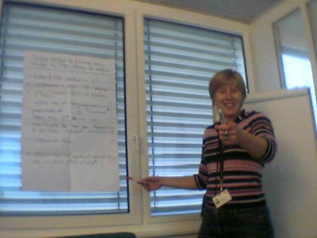Stephanie waving pens at her colleagues while facilitating a decision analysis exercise.